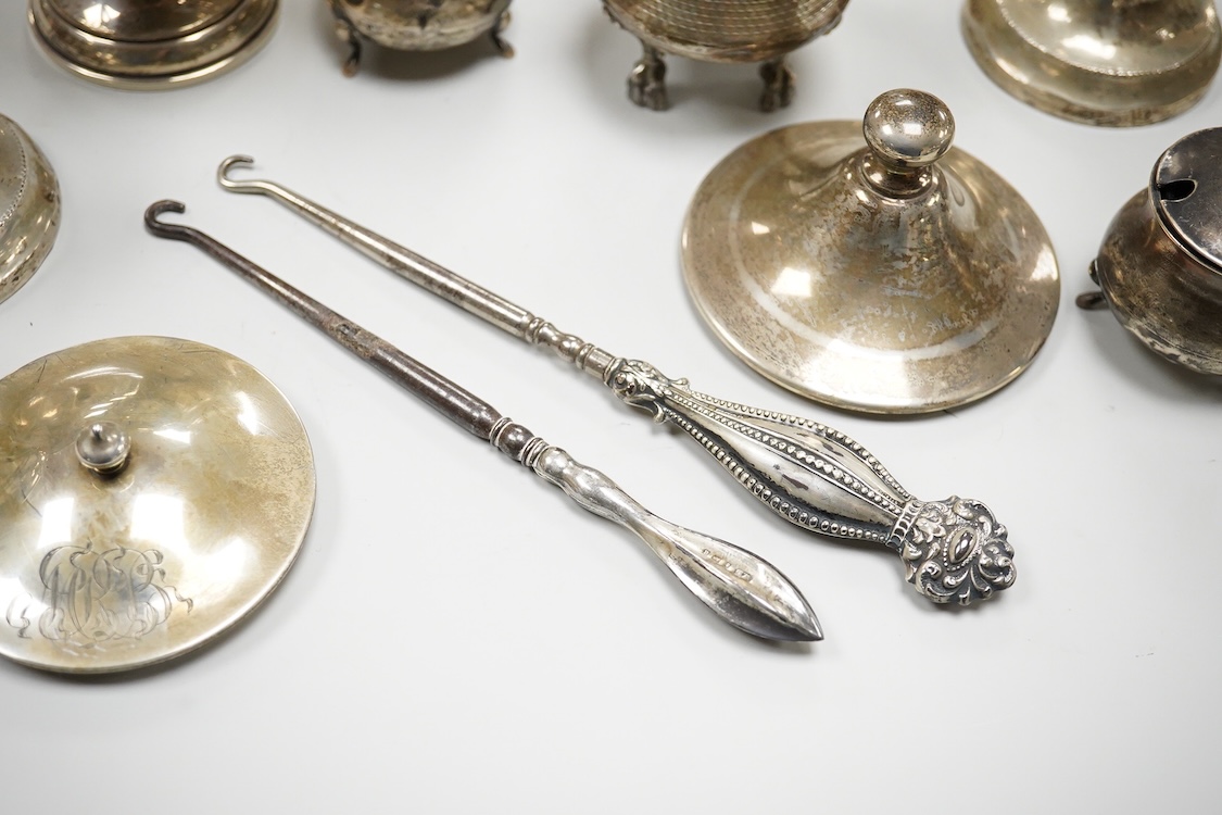 An early 20th century silver mounted cut glass scent bottle, five silver mounted glass toilet jars, a pair of silver mounted dwarf candlesticks, two silver condiments, a sterling jug(weighted), a sterling cup and cover(w